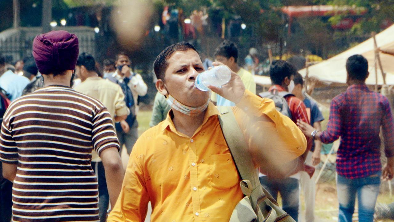 A man takes a sip of water while walking in the scorching heat. Pic/Satej Shinde
 