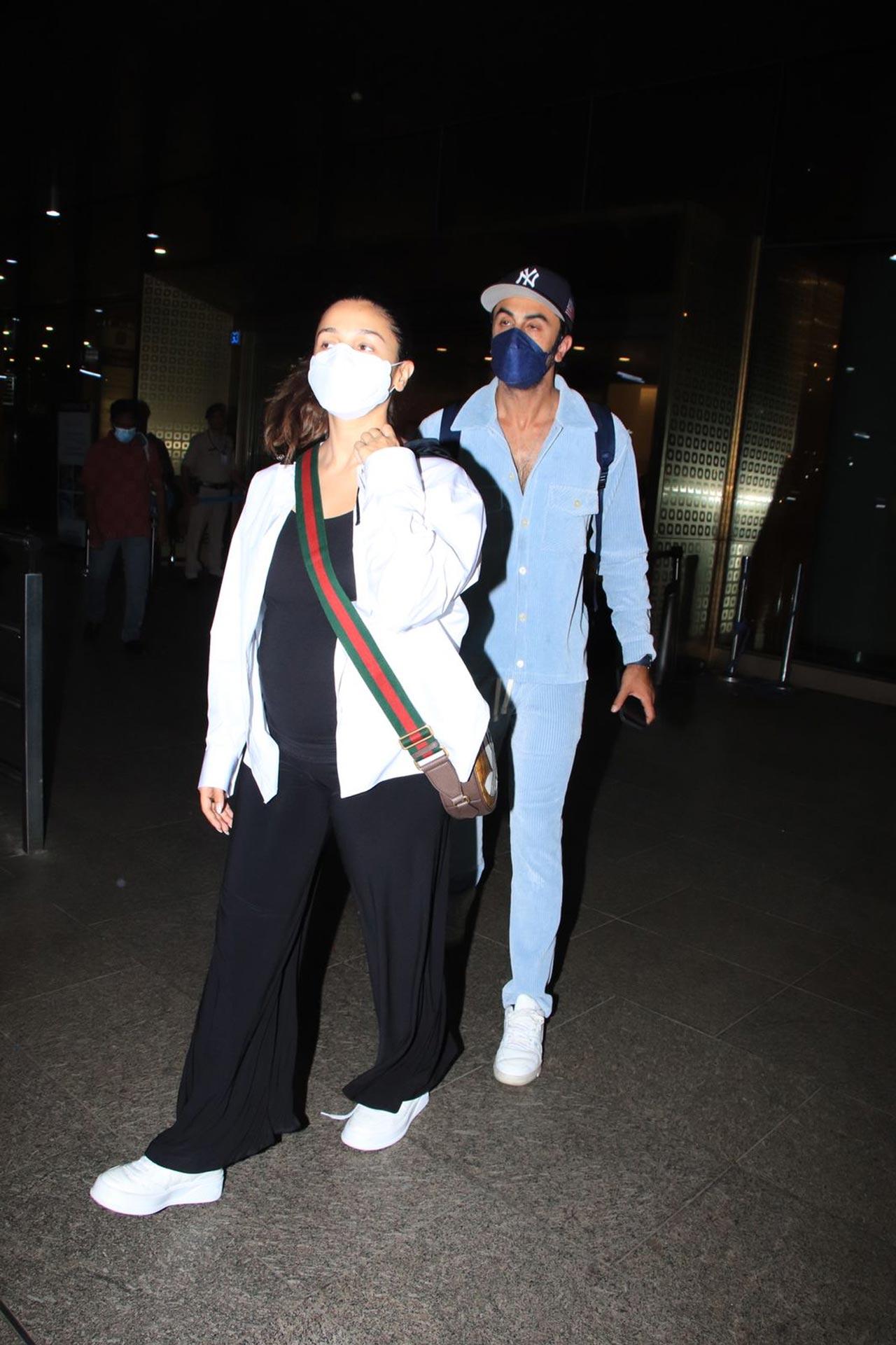 For the airport look, Alia wore an all-black ensemble with a white jacket and matching sneakers. Ranbir, on the other hand, opted for a blue shirt, matching pants, a cap and white sneakers. Both of them carried bags and wore face masks