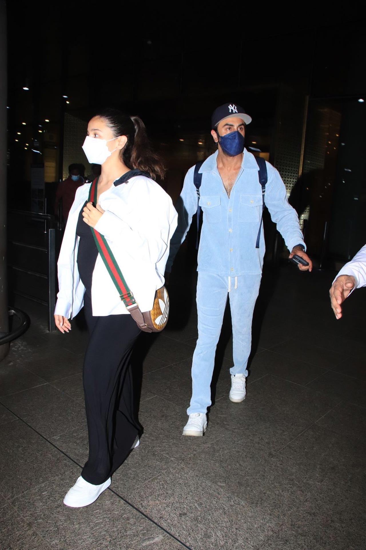 In the pictures, Ranbir and Alia are seen exiting the airport and making their way to their car. Ranbir, the doting husband, is seen protecting Alia from behind as they head towards their car