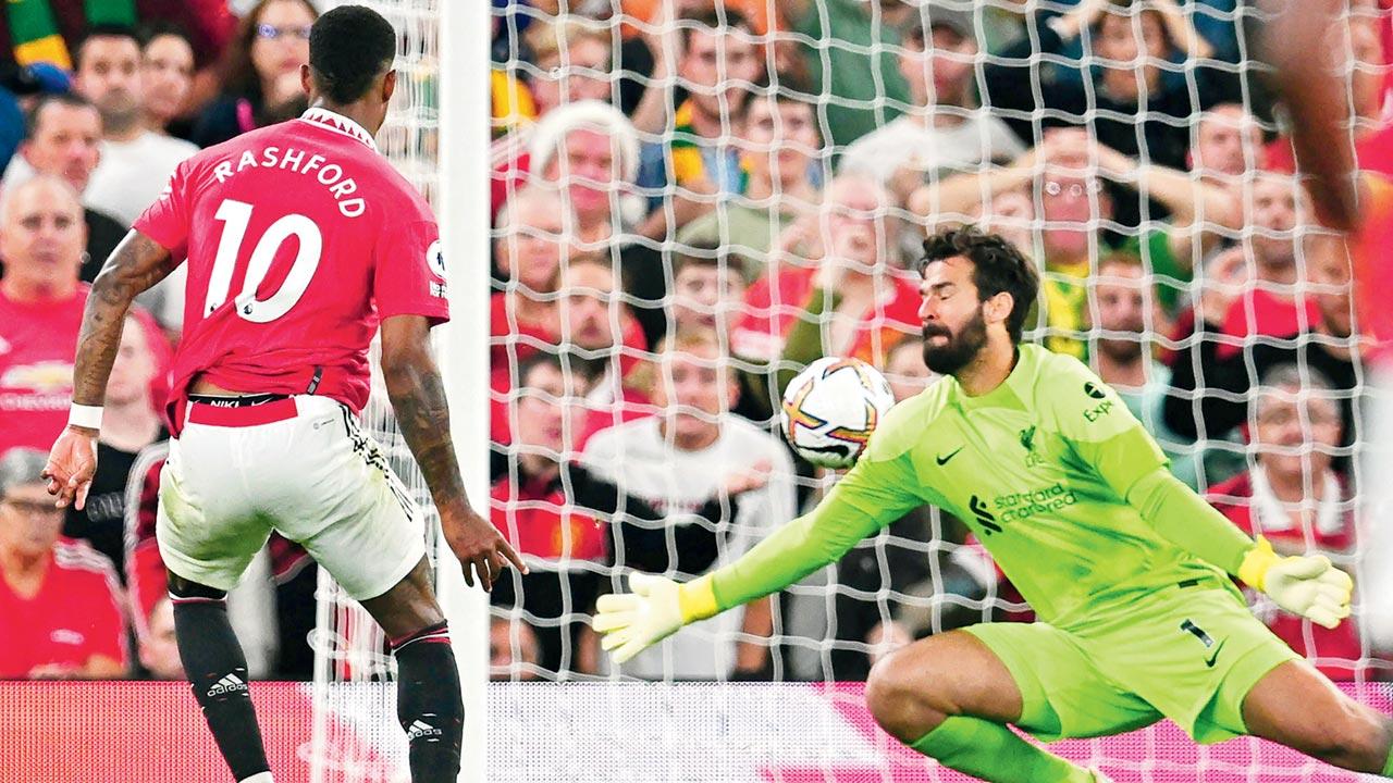 Manchester United’s Marcus Rashford shoots past Liverpool goalkeeper Alisson Becker to score their second goal