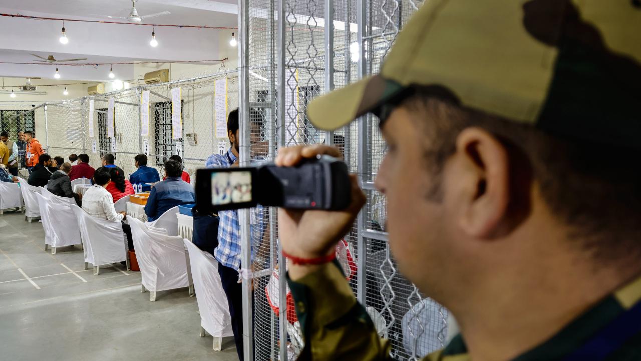 A security personnel makes a video of a counting centre for Gujarat Assembly elections, in Ahmedabad