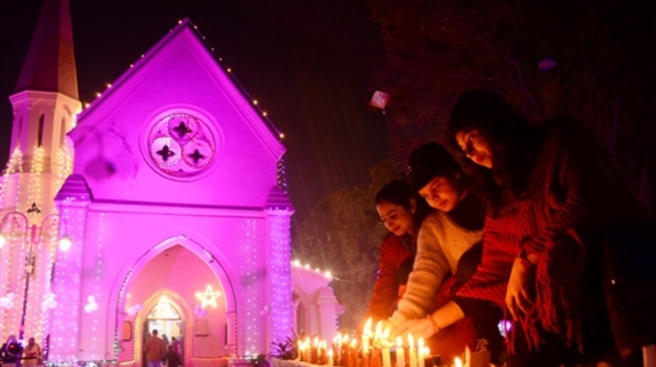 People light candles on the eve of Christmas at St Paul's Church, in Amritsar