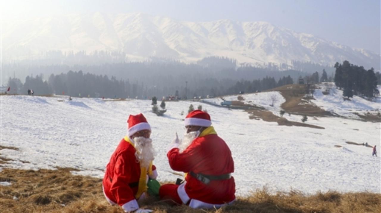 People dressed as Santa Claus celebrate Christmas on its eve, at snow-covered Ski Resort in Gulmarg Pic/PTI
