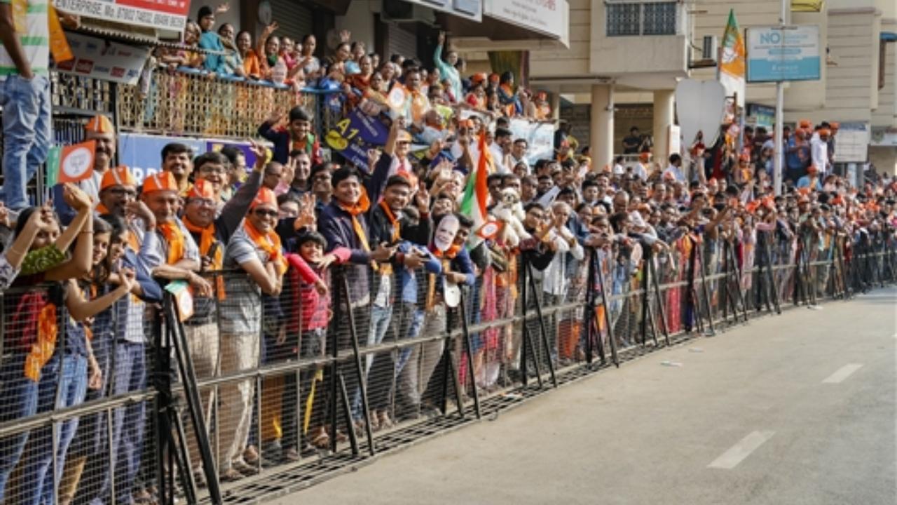 Supporters gather for PM Narendra Modi's welcome near a polling booth during the final phase of the Gujarat assembly elections