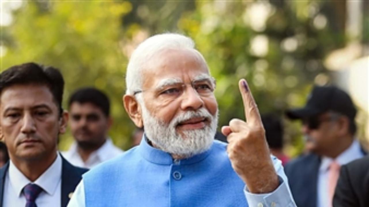 Prime Minister Narendra Modi shows his finger marked with indelible ink after casting his vote