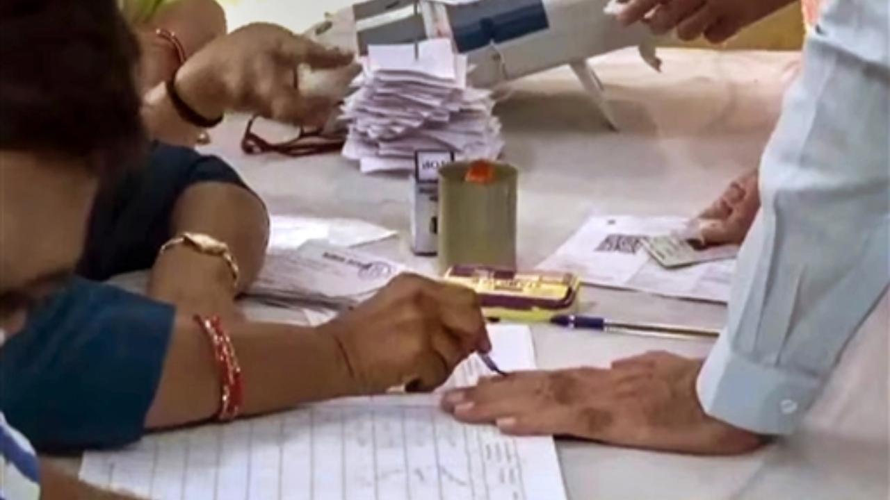 Prime Minister Narendra Modi gets his finger marked with indelible ink before casting his vote