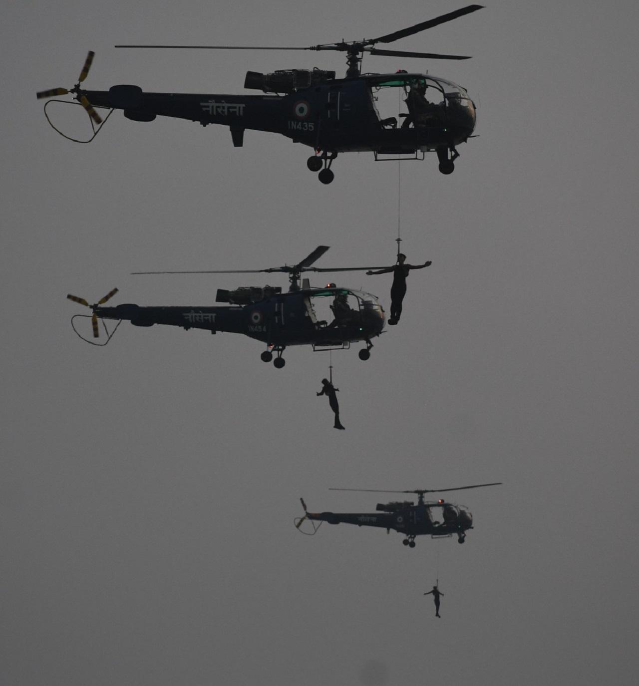 Marine Commandos (MARCOS) of the Indian Navy is suspended from a helicopter during the Navy Day celebrations at the Gateway of India in Mumbai 