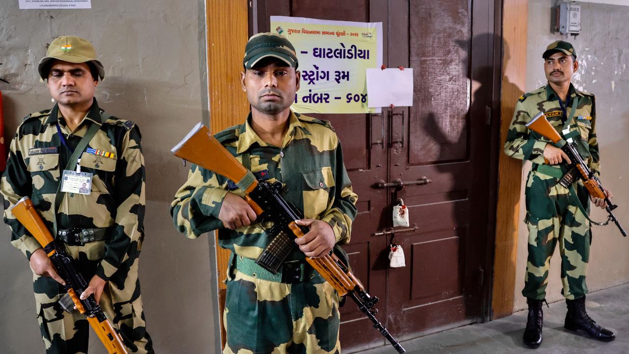 Security personnel stand guard outside a strong room ahead of counting of votes for Gujarat Assembly elections, in Ahmedabad