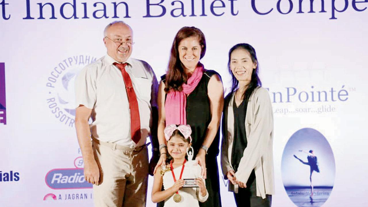 A participant receives an award from Dr Sergey Fondeev, Kimberly Martin and Chiiho Sano at a previous edition