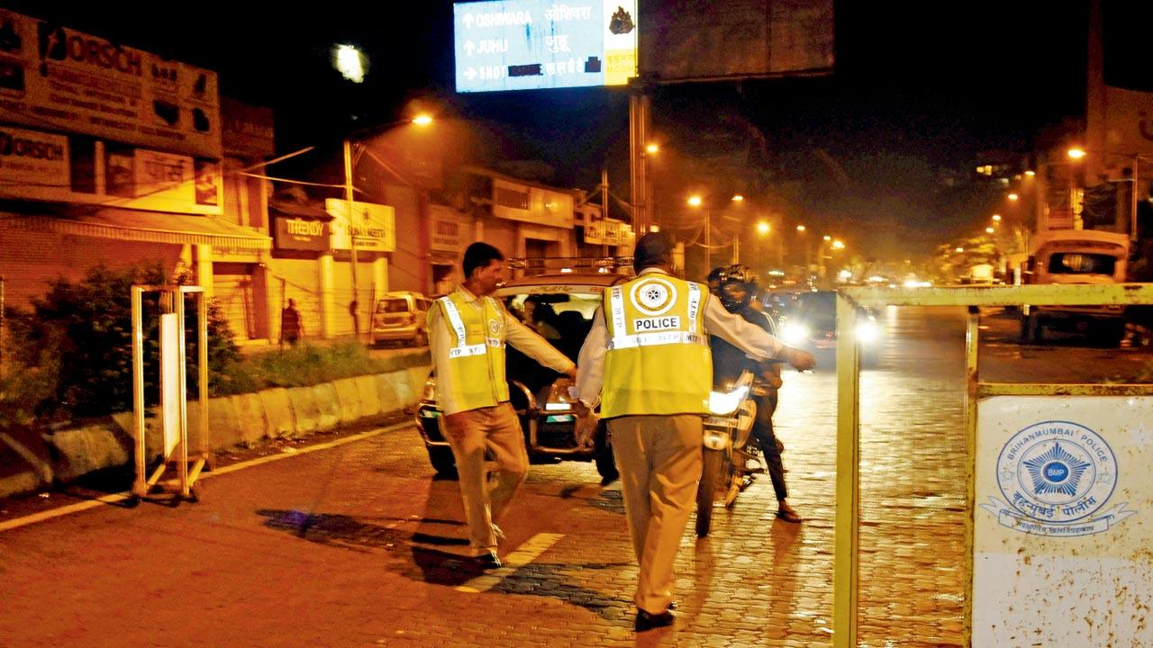 Traffic cops ask a motorist to stop during a drink-driving check, at Juhu