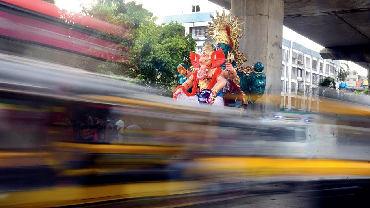 Traffic whizzes past the Andhericha Raja under the Mumbai Metro  bridge at Gundavali in Andheri East during the procession that was taking it to the pandal. Pic/Ashish Rane