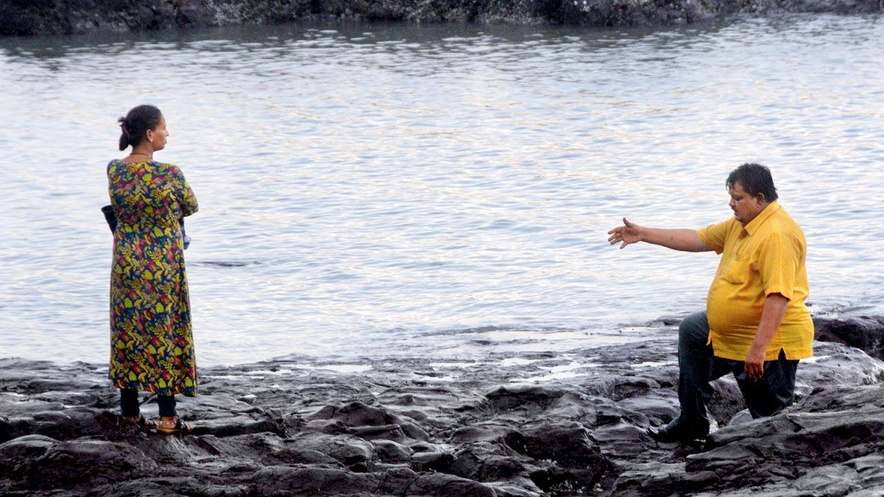 A man appears to reach out his hand to his partner on the rocks at Bandra’s Bandstand. Pic/Satej Shinde