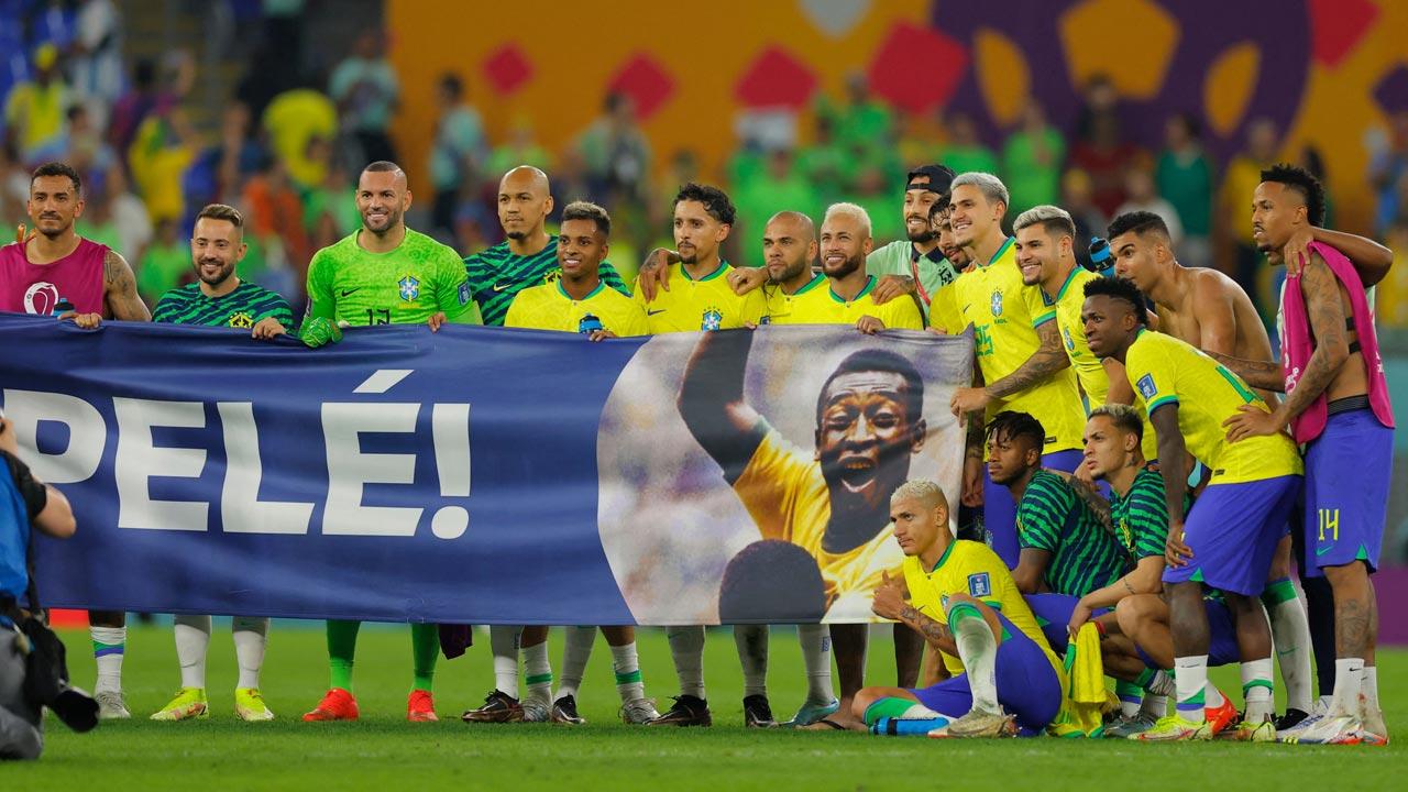 Brazil players stand behind a banner honouring Brazilian football legend Pele after they won the Qatar 2022 World Cup round of 16 football match between Brazil and South Korea at Stadium 974 in Doha
