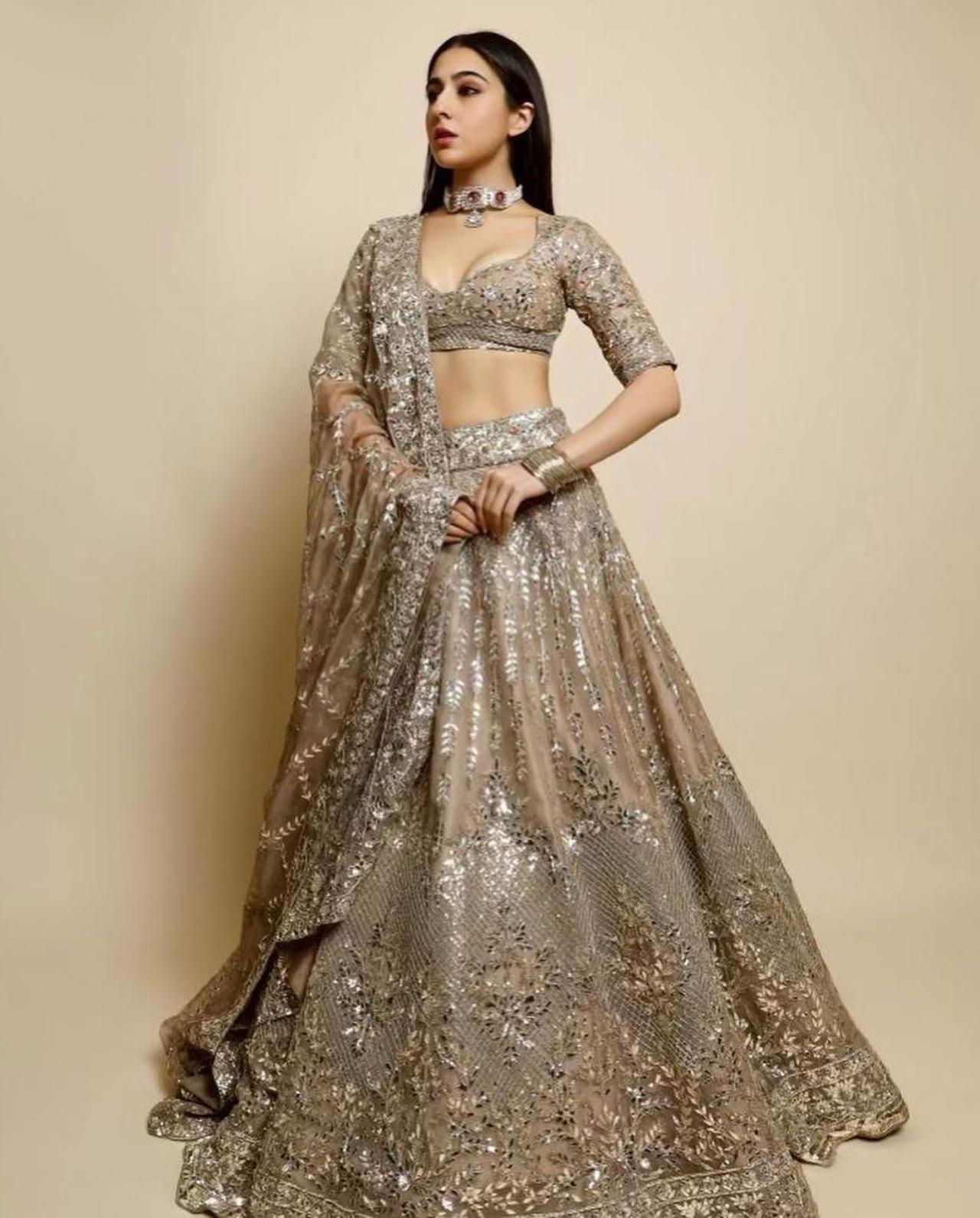 Sara Ali Khan looked every bit royal in this timeless gold look with heavy embroidery work. The fine work on the blouse and lehenga add to the beauty of the ensemble . She completed the look with a choker necklace and metallic bangles