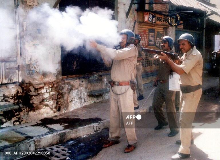Police fire teargas at rioters in the Shahpur area of Ahmedabad on 22 April 2002.