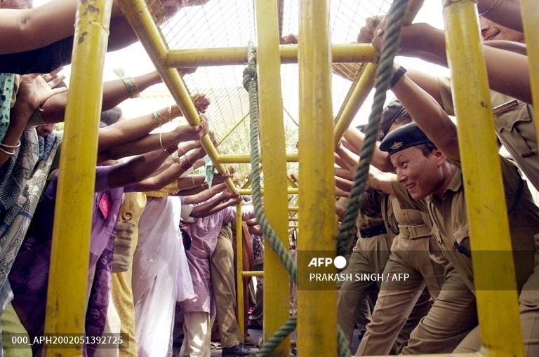 Women protesters (L) push a police barricade during a march organised by several women organisations to express solidarity with those who were allegedly raped during Gujarat's sectarian riots, in New Delhi on March 13, 2002