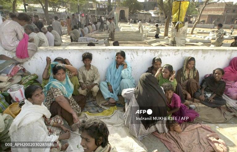 Homeless people whose houses were burnt during riots, sit at a camp in Bapu Nagar in Ahmedabad