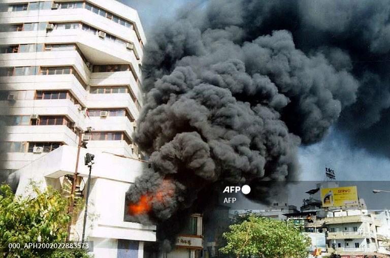 Smoke billows from a building set alight by rioters in Ahmedabad on February 28, 2002