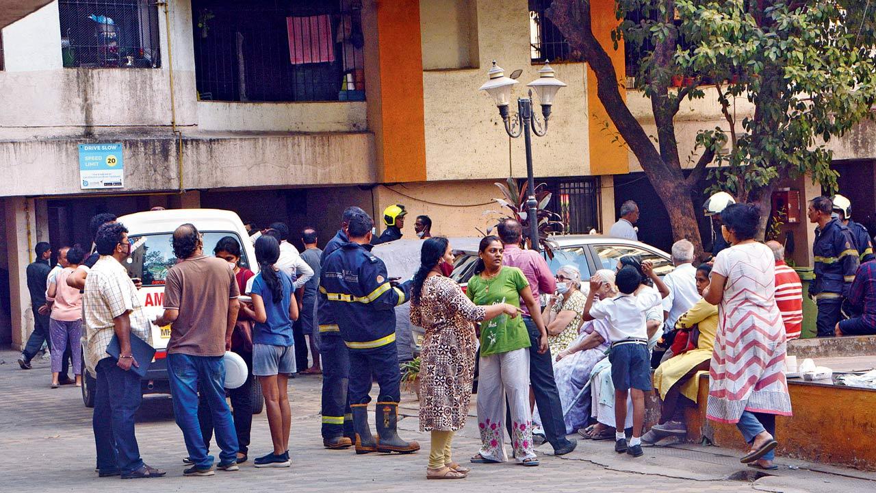 Residents in the compound of NG Royal Park as fire officials douse the blaze. Pic/Satej Shinde