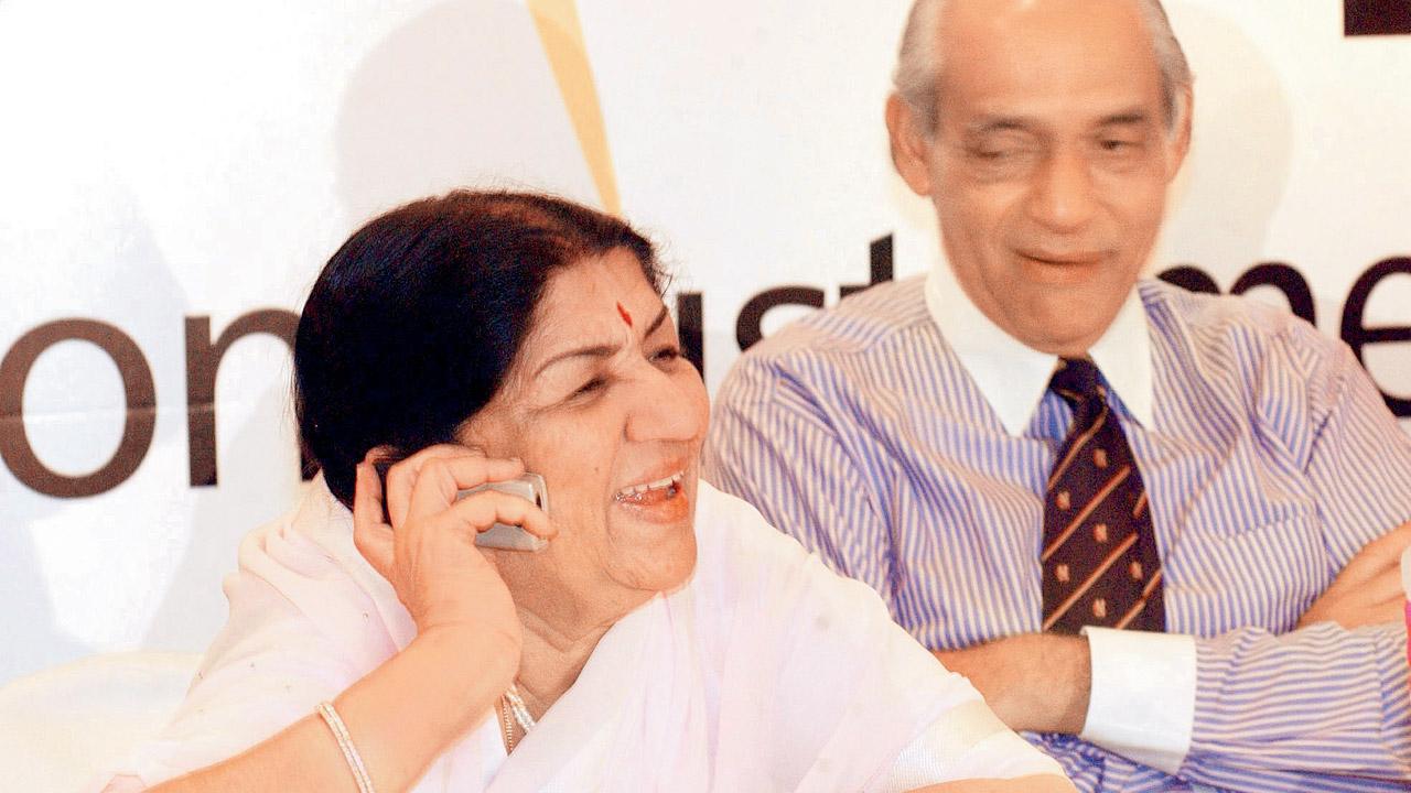Lata Mangeshkar watched by ex-BCCI chief Raj Singh Dungarpur officially invites Sachin Tendulkar over the phone to be part of an India Invitational XI v Sri Lanka Invitational XI match to raise funds for the Dinanath Mangeshkar Hospital in Pune. The match was held at Wankhede on March 29, 2003. Pic/MID-DAY Archives