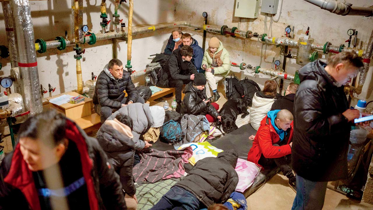 People take shelter in a building’s basement while sirens sound new attacks in the city of Kyiv