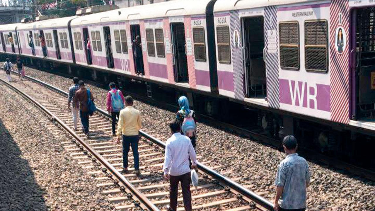 Commuters walk on tracks between Mumbai Central and Grant Road stations on Sunday