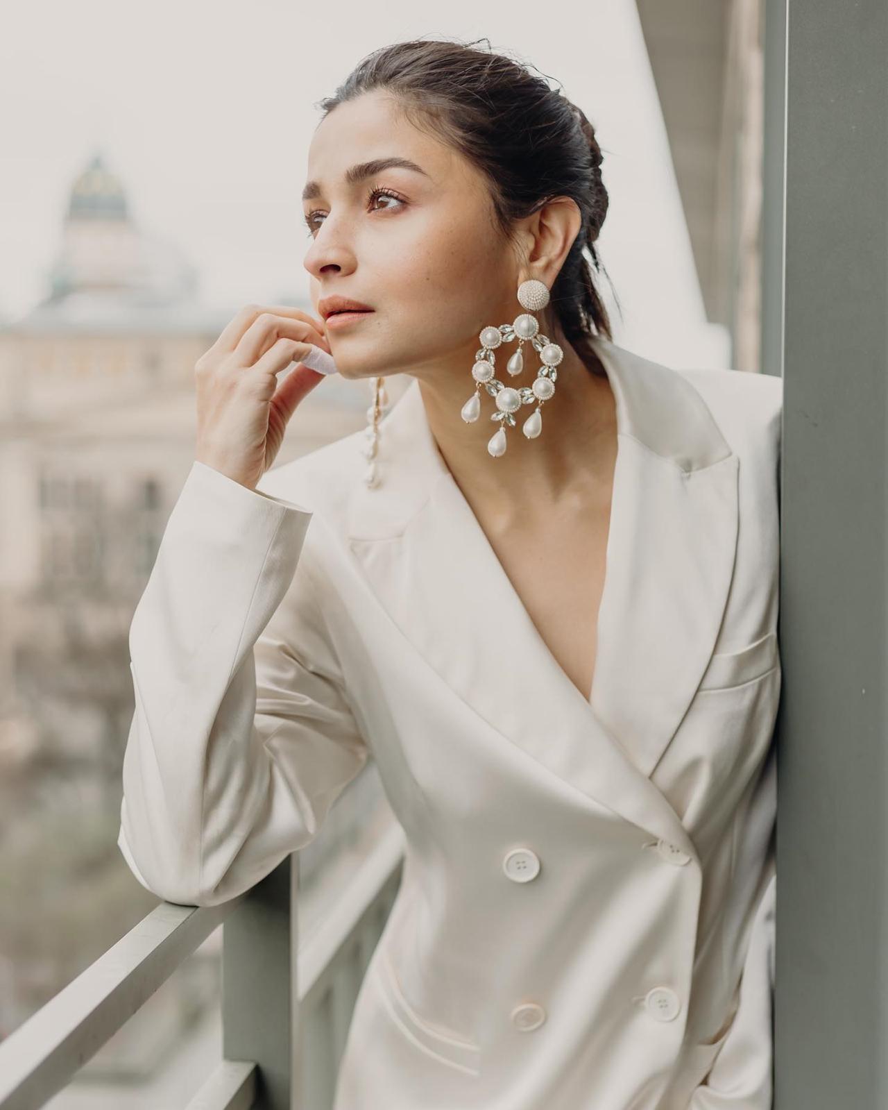 Taking to her Instagram handle on Wednesday, Alia shared pictures in which she looks drop-dead gorgeous, dressed in a white power suit, teamed with a flowy matching lower. She tied her hair back and kept her make-up natural. The highlight of her classy look is the gorgeous pair of ivory-and-gold earrings
