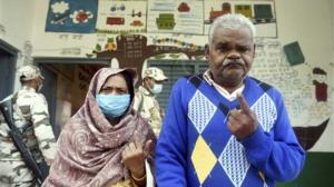 An elderly couple leaves after casting votes for Assembly elections at a polling station in Unnao on Wednesday. Pic PTI