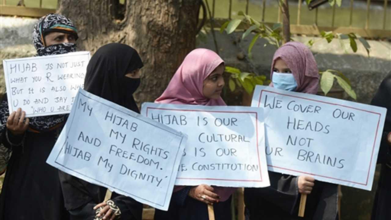 Members from the Muslim Women Association hold placards as they stand along a roadside during a silent protest after few Karnataka`s educational institutes denied entry to students wearing hijabs, in Hyderabad on Tuesday. Pic/ PTI