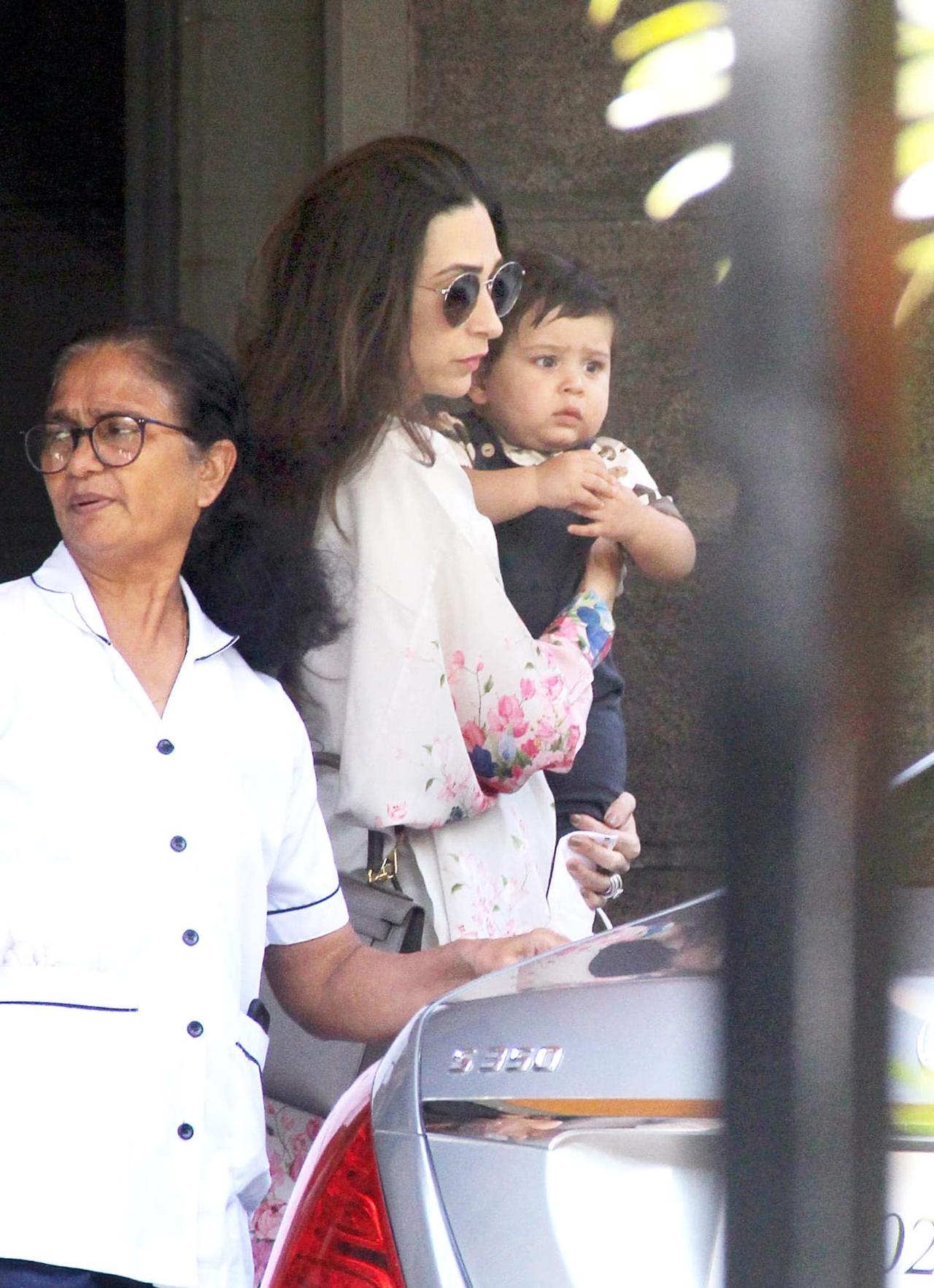 Baby Jeh looks adorable as aunt Karisma holds the tiny tot as he arrived at the celebration.