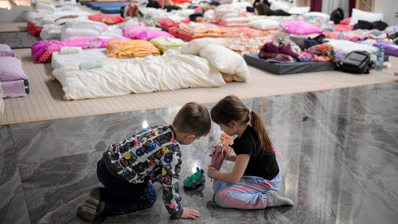 Children who fled the conflict from neighboring Ukraine play on the floor of an event hall in a hotel offering shelter in Siret, Romania. Pic/PTI