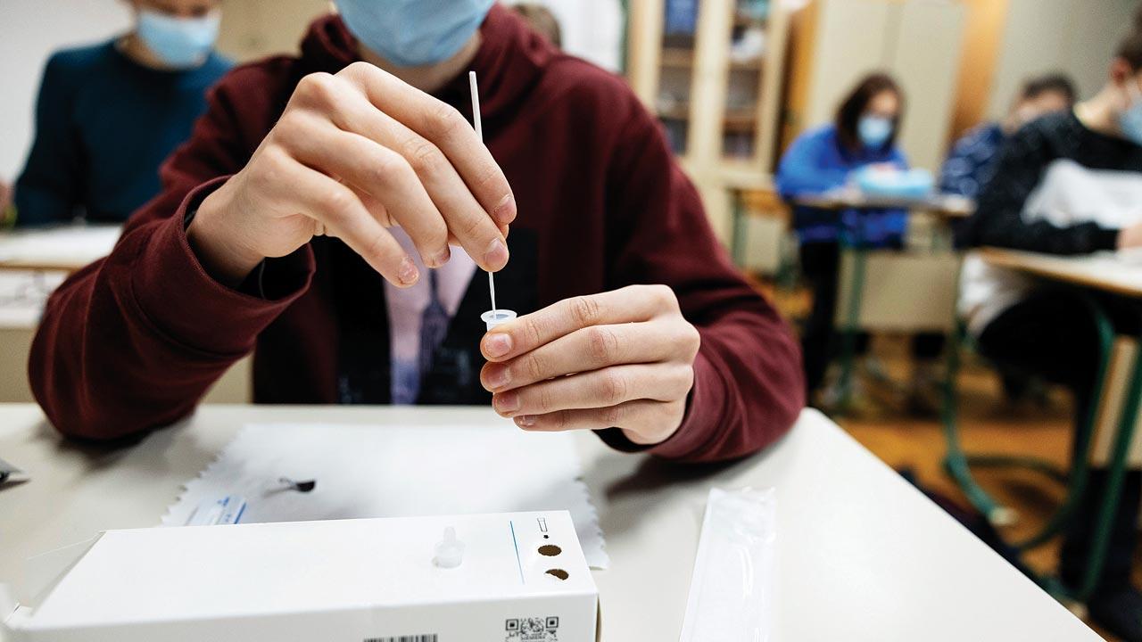 A student self-tests with a rapid COVID-19 antigen self-test kit in a primary school in Kranj, Slovenia. All primary and secondary school children in Slovenia are required to self-test in school three times a week as the country faces a severe outbreak of COVID-19. Experts feel a similar model should be adopted in India as well. Pic/Getty Images