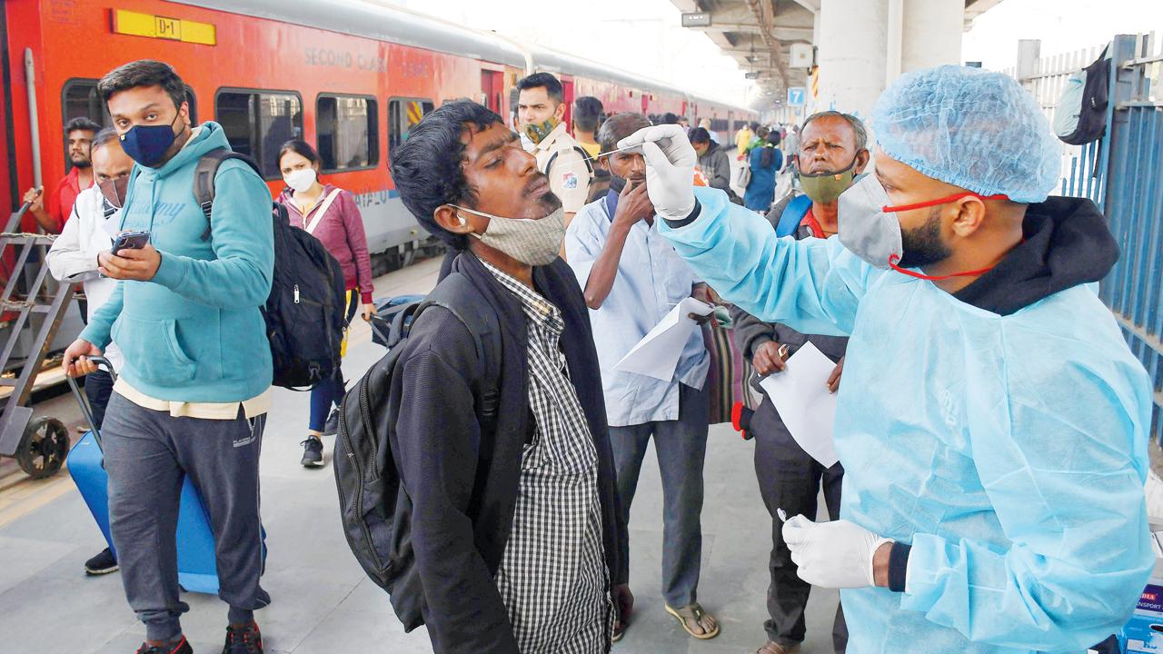 A civic health worker collects a swab sample of a passenger for Covid-19 test, at Dadar station. Pic/Ashish Raje