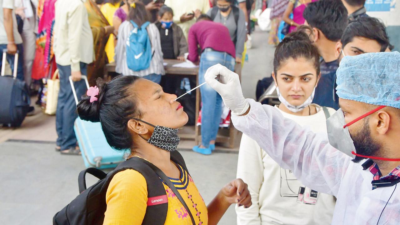 A medic collects a passenger’s swab sample at Dadar station on Tuesday