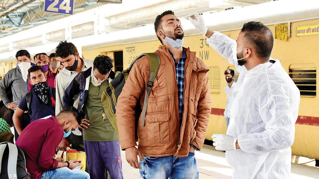 A medic collects a passenger’s nasal swab for Covid-19 test, at Dadar station, on Tuesday. Pic/Suresh Karkera