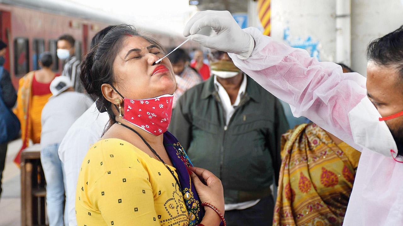 A health worker collects a swab sample at Dadar station on Sunday. Pic/Ashish Raje