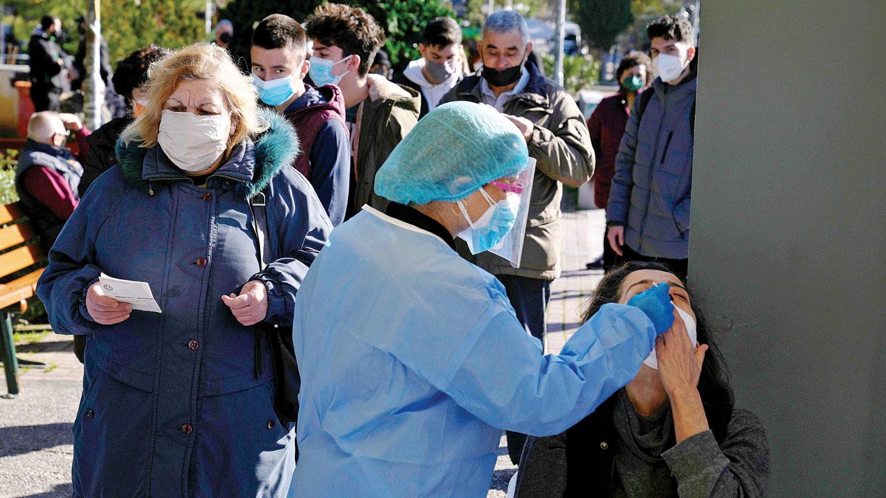 Medical staff conduct a COVID-19 rapid test on a woman in Athens, Greece on Monday, where Omicron cases are high. Pic/AP