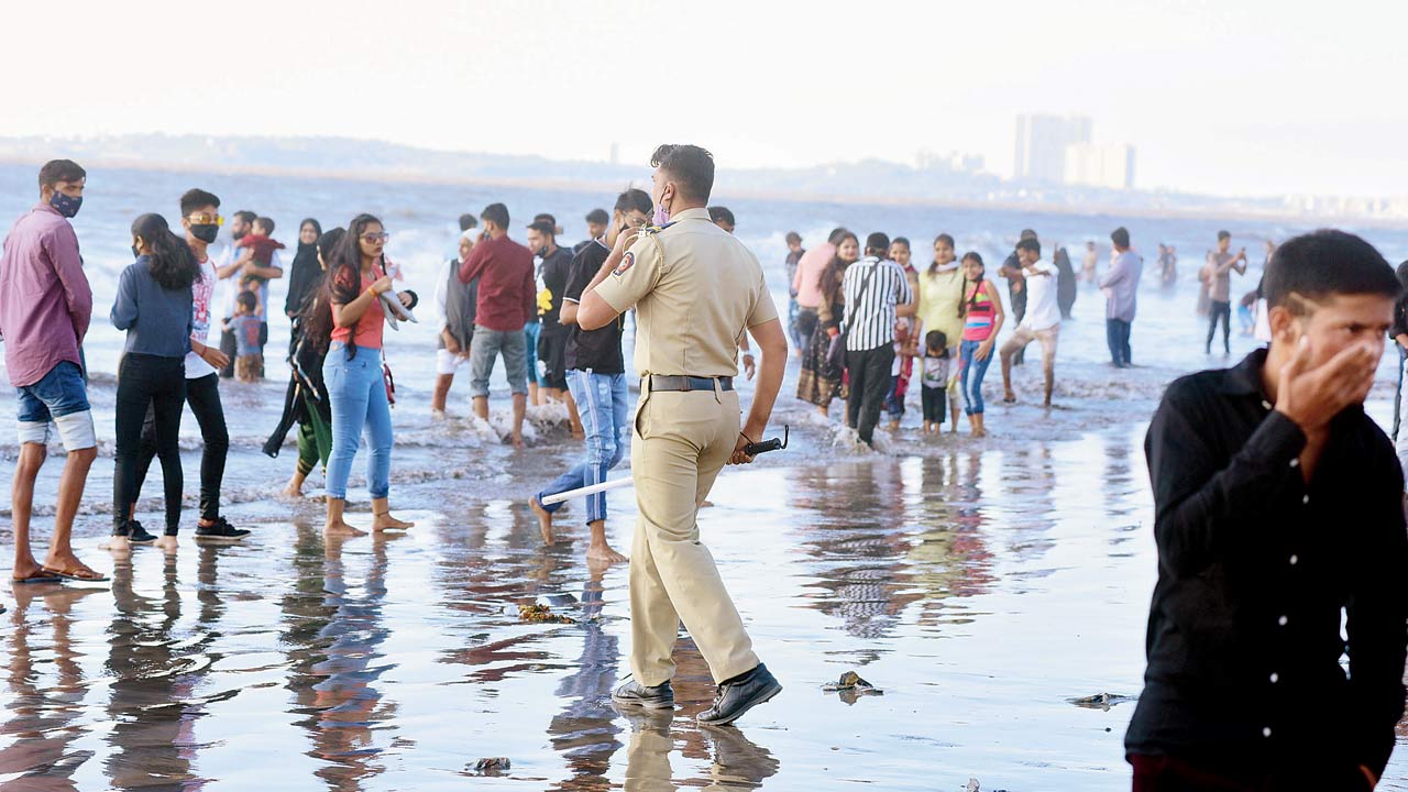 A cop asks visitors to leave the beach after 5 pm, as per the new guidelines. Pics/Shadab Khan