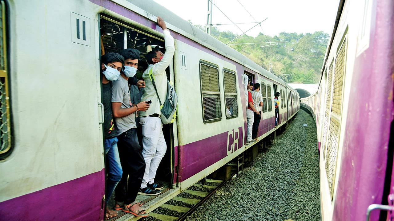 Commuters stand on the footboard of a local train, while travelling between Kalwa and Mumbra, on December 20, 2021. Pic/Atul Kamble