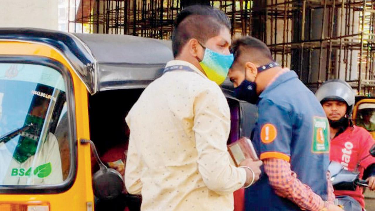 A clean-up marshal without uniform collects fine from a man outside Borivli railway station on Thursday