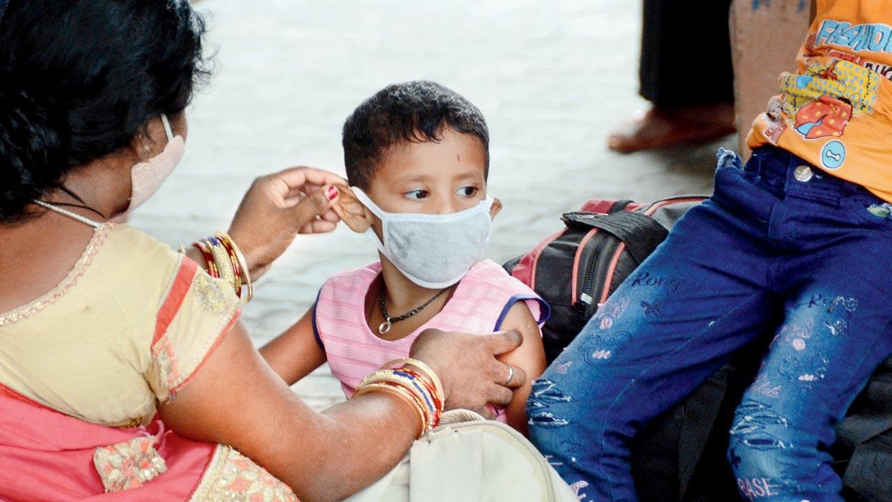 A woman masks up her child at LTT, Kurla. File pic