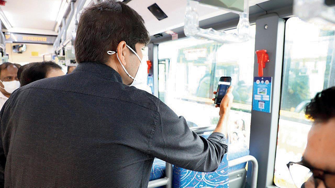 Abhijit Bangar, Navi Mumbai civic chief, scans the QR code pasted on the bus to get a book to read on his smartphone