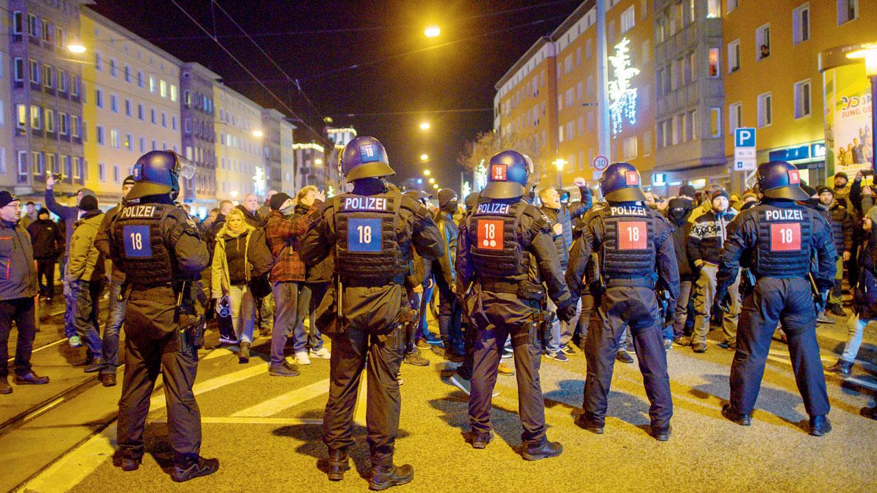 Police officers and participants of a meeting to protest measures enacted by the state of Saxony-Anhalt to contain the coronavirus face each other in Magdeburg, Germany, on Monday. Pic/AP