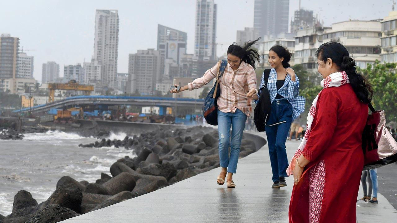 People enjoy the monsoon at Marine Drive on July 14. Pic/Ashish Raje