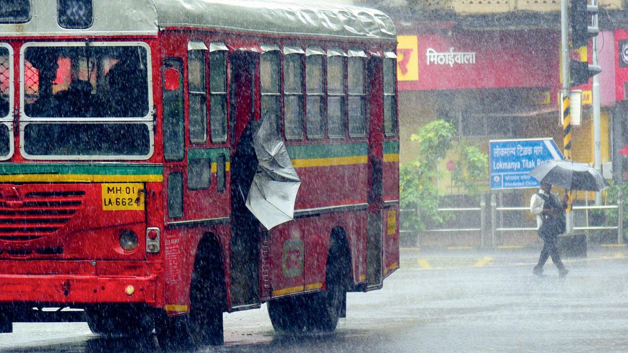 A passenger struggles to shut his umbrella on the bus, at Dadar TT, on Wednesday. Pic/Pradeep Dhivar