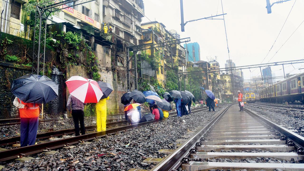Civic and railway officials take down the remaining part of the dilapidated wall near Masjid Bunder station. Pics/Shadab Khan