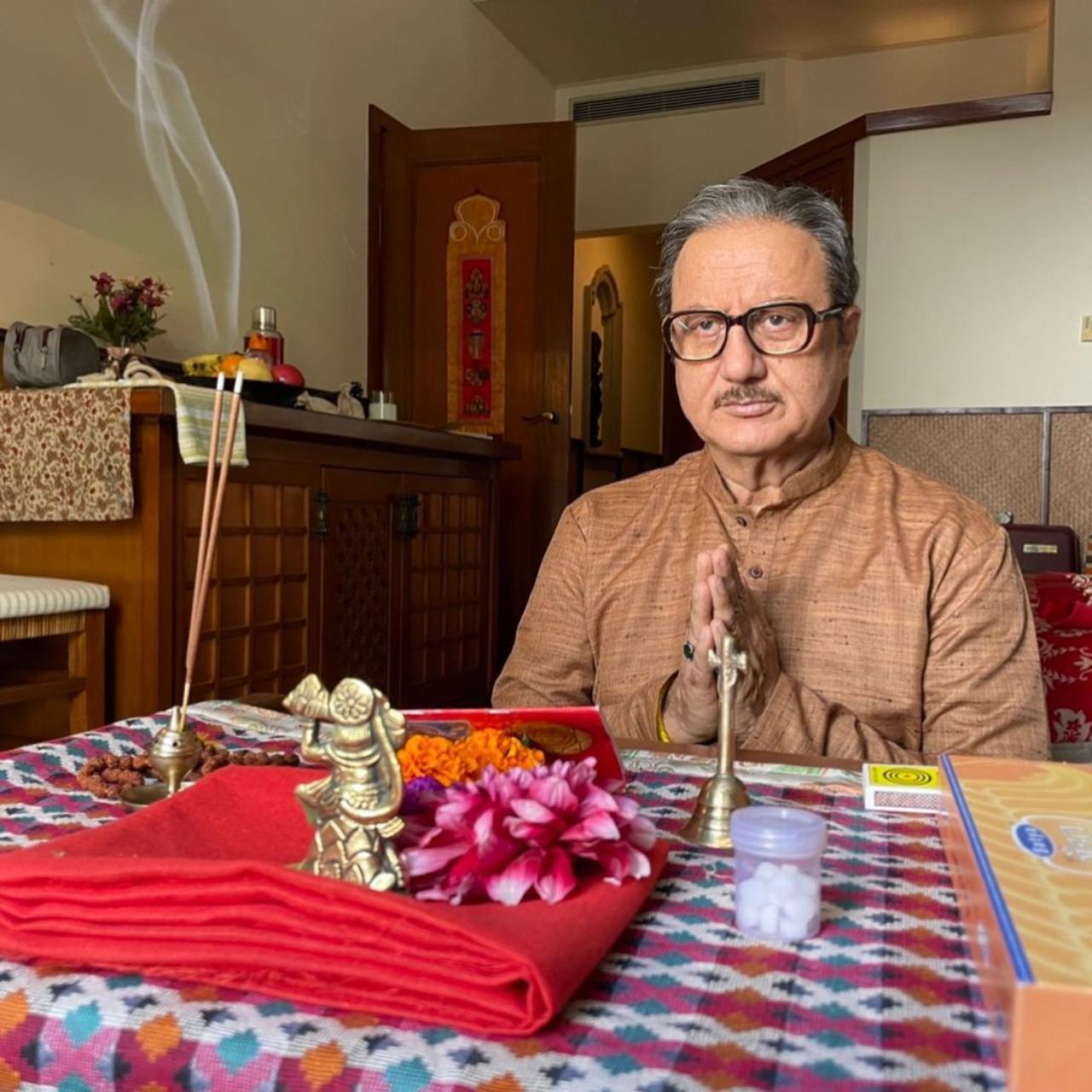 In one of the pictures, Kher is seen praying to God before his shot. He could be seen donning a khaki kurta pyjama with big frame spectacles, and a wig. In one of the pictures, Kher is seen praying to God before his shot. He could be seen donning a khaki kurta pyjama with big frame spectacles, and a wig.