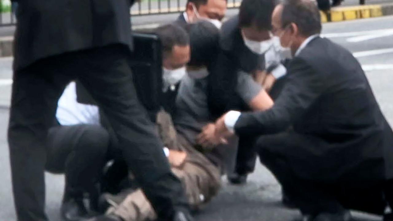 A man, center, is detained near the site of gunshots in Nara, western Japan. Pic/PTI