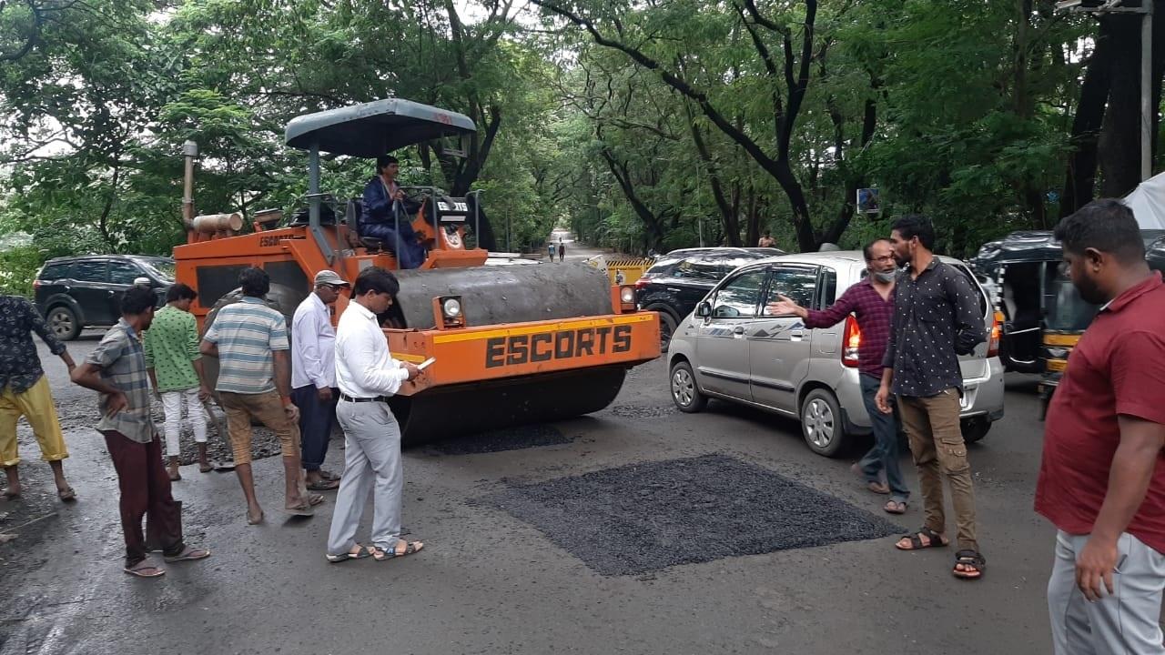 An official overseeing the pothole filling process at Aarey Market in Mumbai