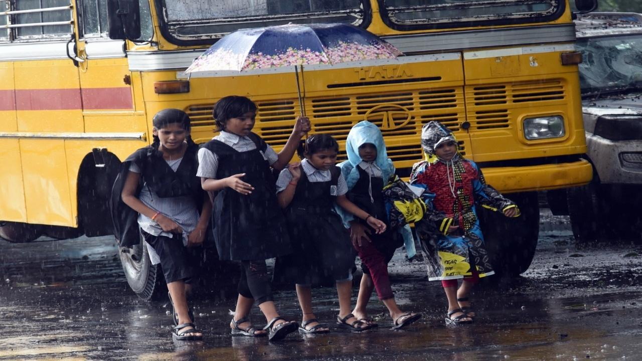 Children going to school amid torrential rains in Powai